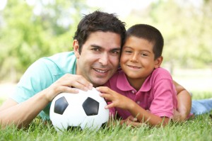 Father And Son In Park With Football